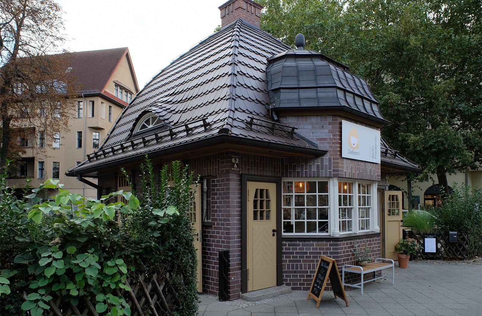 Café Debatchi mit Garten im denkmalgeschützten Häuschen am Südwestkorso; das knapp 6 x 6 Meter große Gebäude wurde 1920 nach den Plänen des Berliner Architekten und Baurats Hans Altmann als Kiosk mit Bedürfnisanstalt (öffentliche Toilette) gebaut und in den letzten Jahren komplett saniert