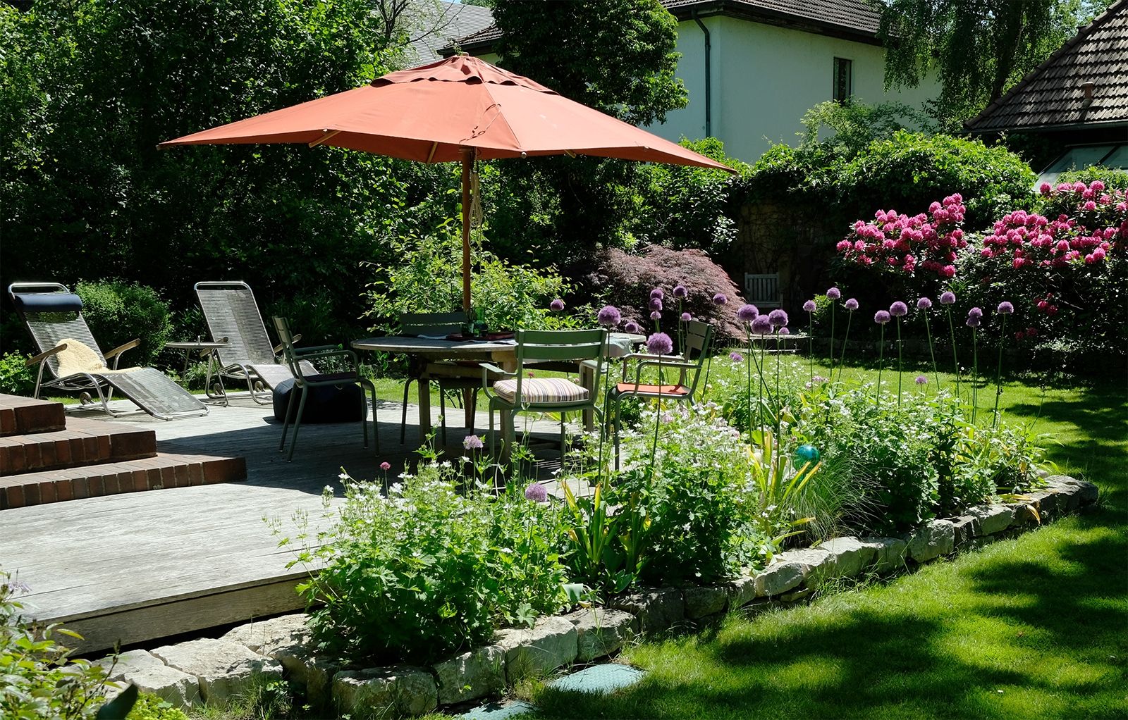 Das Terrassendeck aus Robinienholz ist neben der Veranda eine zweite Erweiterung des Wohnbereichs; noch ziemlich neu ist die zu jeder Jahreszeit anders prachtvoll blühende Gestaltung rund um das Deck von Gartenarchitektin Karen Lüdemann