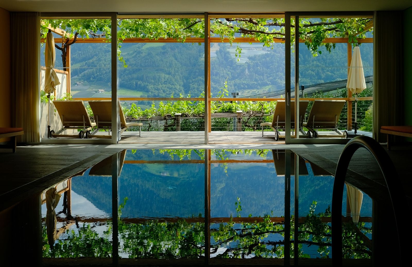 Die Pergola Residenz wurde 2004 nach den Plänen des Architekten Matteo Thun erbaut; an den Holz-Pergolen, wie hier vor dem Indoor Pool und Spa-Bereich, ranken Schatten spendende Weinreben empor