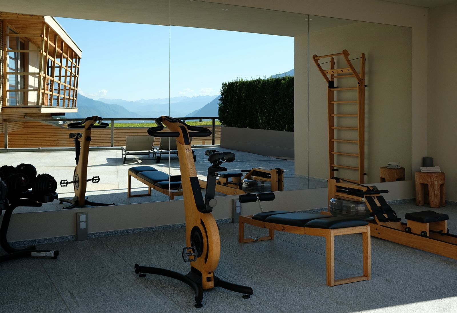 Die Berge im Blick – Verspiegelter Gym-Bereich des Spazio 46 mit Sportgeräten von Nohrd und WaterRower