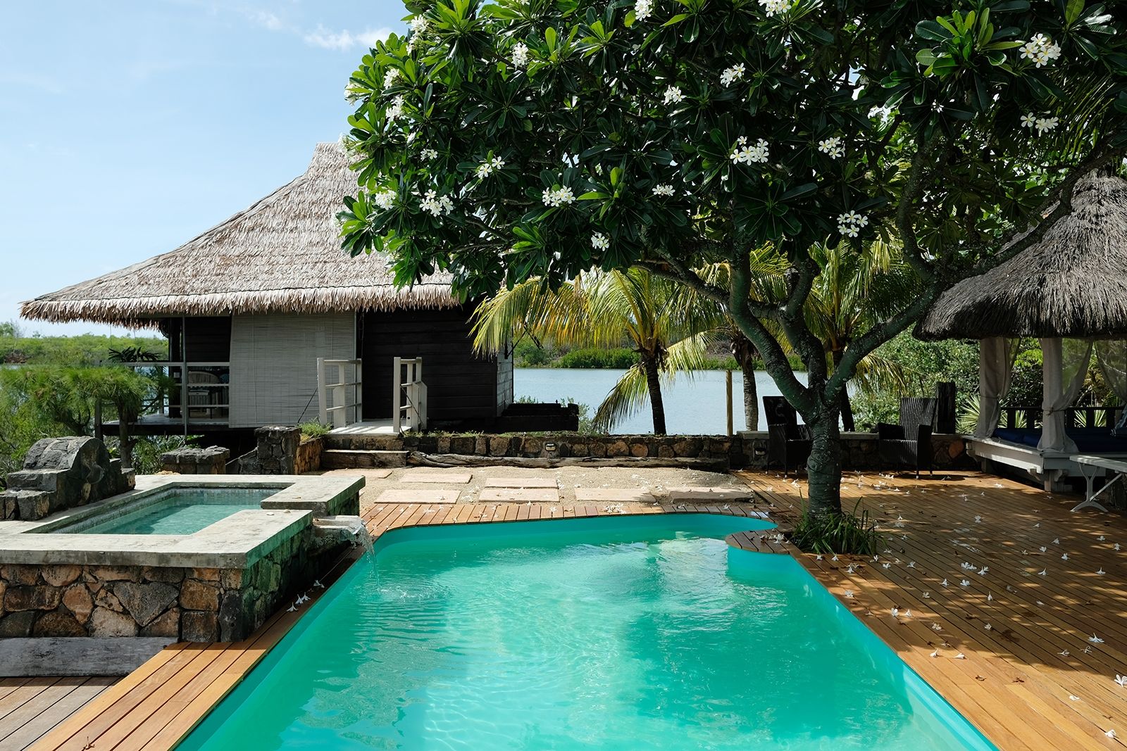 Pool-Terrasse mit Blick auf das 2011 gebaute Holzhaus Le Faré, das für zwei Personen buchbar ist und ein eigenes Bad besitzt; von hier haben die Gäste eine unbeschreibliche Aussicht vom Bett und der Terrasse auf die Bucht; auf dem frisch sanierten Holzdeck lässt sich wunderbar Yoga praktizieren