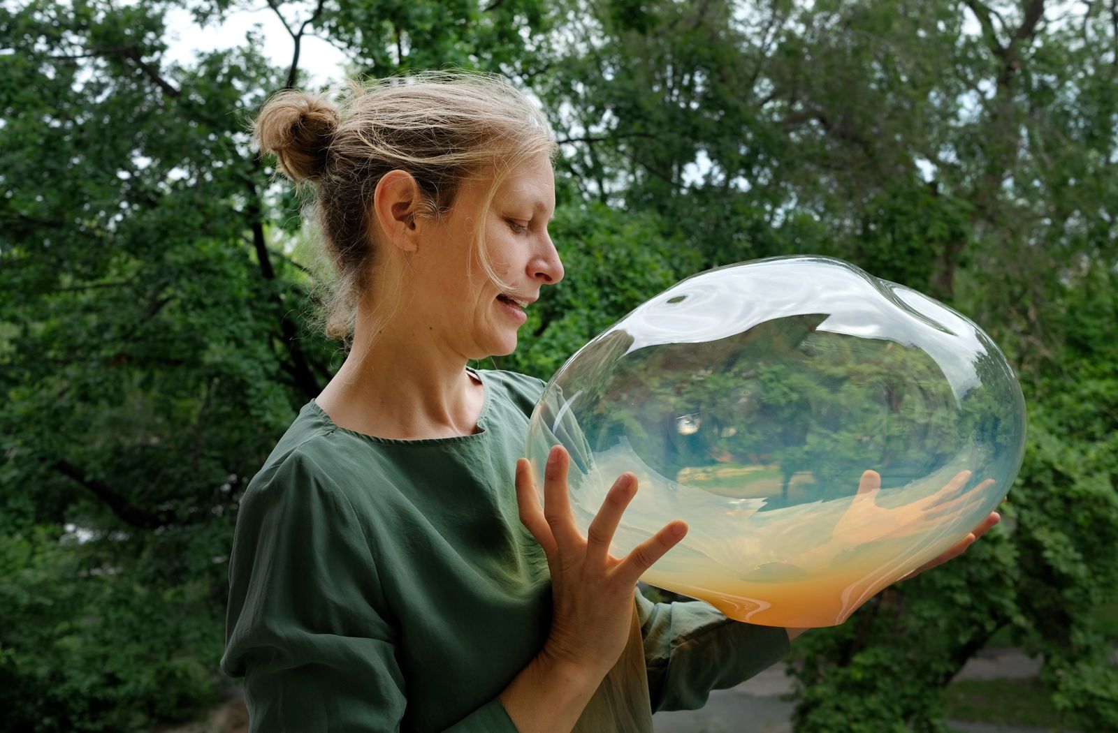 Designerin Simone Lüling mit einem irisierenden Lampenglas