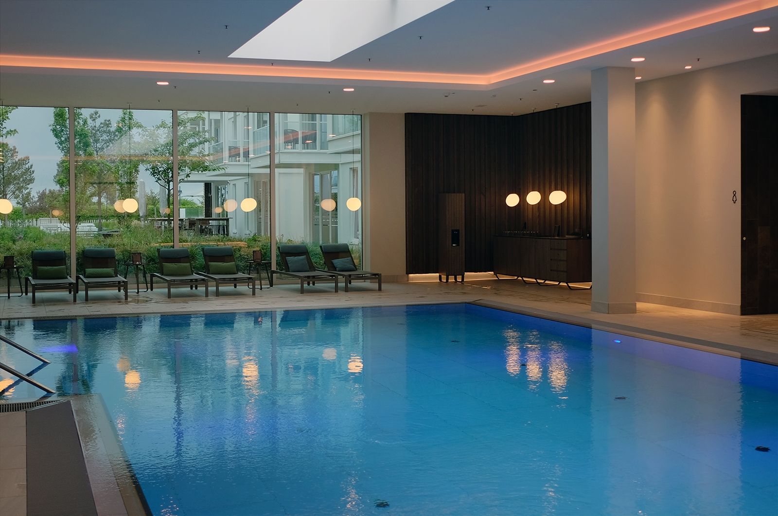Großzügig und entspannend nicht nur bei regnerischem Wetter: 639 The Vela Spa mit großem Pool, Kinderbecken, vier Saunen, Ruhezonen mit Feuerstelle, beheizten Wärmeliegen und Anwendungsräumen für Treatments