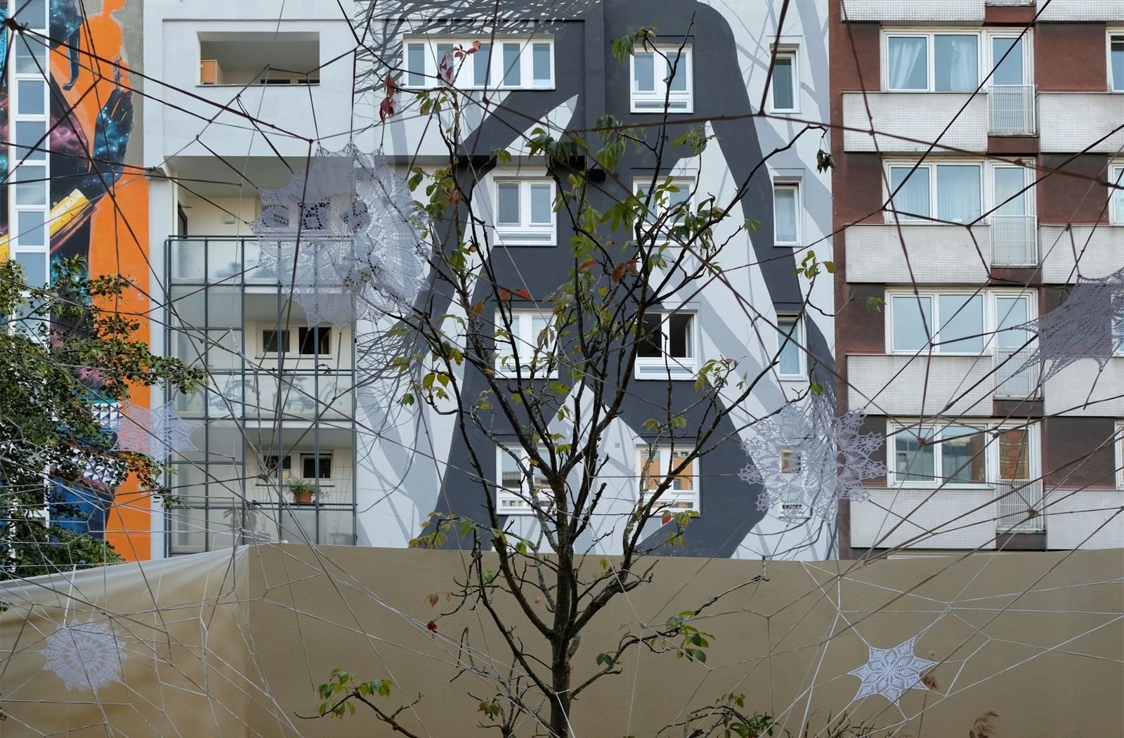 »Untitled«, Nespoon, Spinnennetz aus Häkeldeckchen vor »One Wall«-Fassade von David de la Mano